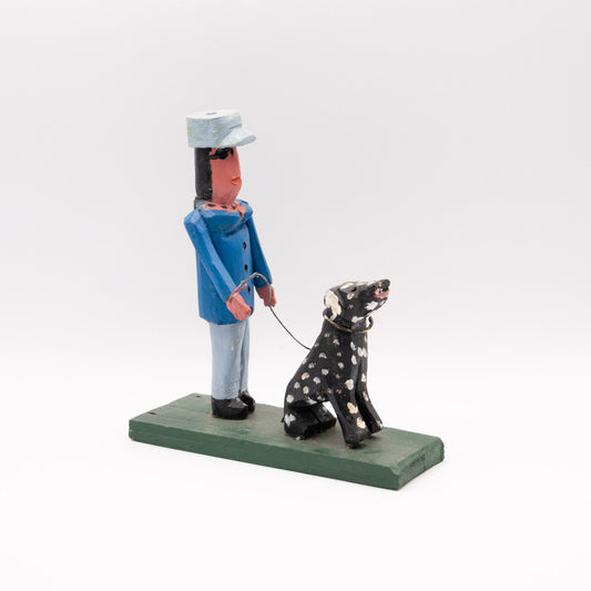 Femme en bleu promenant son dalmatien noir